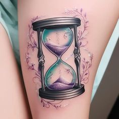 a woman's thigh with an hourglass tattoo on it