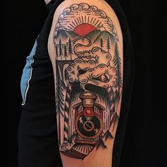 a man with a tattoo on his arm has a clock and mountains in the background