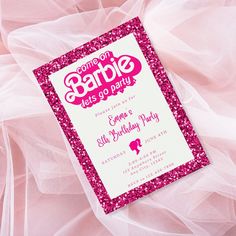 a pink and white birthday party card with sparkles on the bottom, sitting on a bed sheet