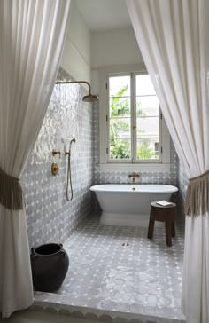 a bath room with a tub a window and a stool on the floor in front of it