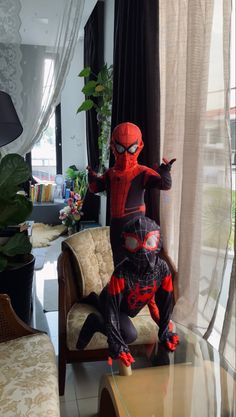 a spider man statue sitting on top of a table next to a couch in a living room