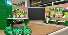 an exhibit with green letters and people sitting at tables in front of the sign that says gro