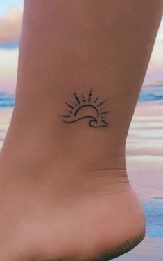 a small sun and wave tattoo on the ankle