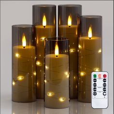 several candles with remote controls in front of them