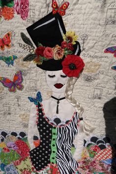 a woman wearing a hat with flowers on her head and dress made out of fabric