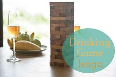 a wooden block tower sitting on top of a table next to a glass of wine