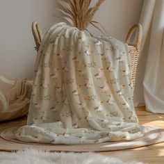 a blanket is draped on the floor next to a wicker basket and some plants