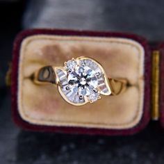 an engagement ring in a velvet box with a diamond center stone on the front and side