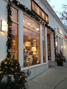 a store front with christmas decorations and lights on the windows