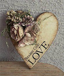 a heart shaped wooden sign with flowers on it