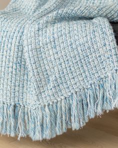 a blue and white blanket sitting on top of a wooden floor