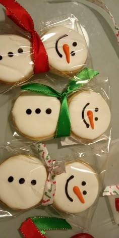 four decorated cookies in the shape of snowmen