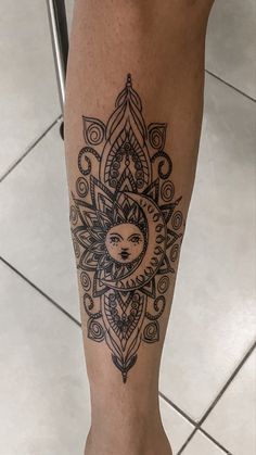 a woman's leg with a sun and moon tattoo on it