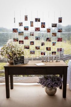 a table with pictures and flowers on it in front of a window that is decorated with photos