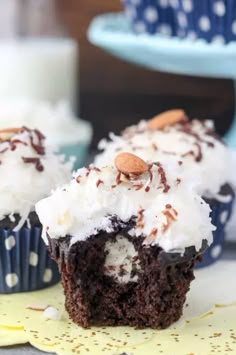 chocolate cupcakes with white frosting and nuts on top