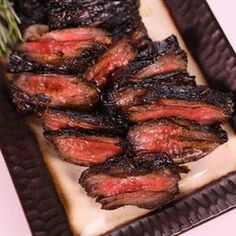 grilled steaks and mushrooms on a plate with herbs in the middle, ready to be eaten