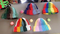 several knitted beanies are arranged on a table