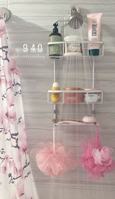 there is a shower curtain with pink flowers and soaps hanging from it's hooks