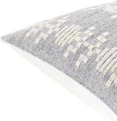 a gray and white pillow on a white background