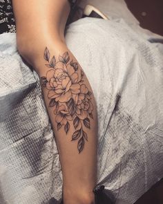 a woman's leg with a flower tattoo on it