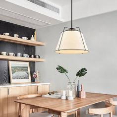 a dining room table with four chairs and a potted plant