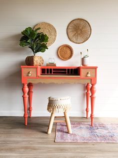 an orange desk with two baskets on top and a potted plant sitting next to it