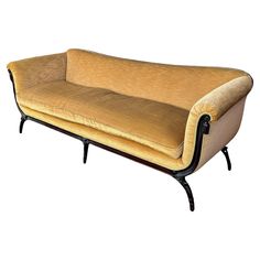 an old fashioned couch with black legs and a tan upholstered fabric on it