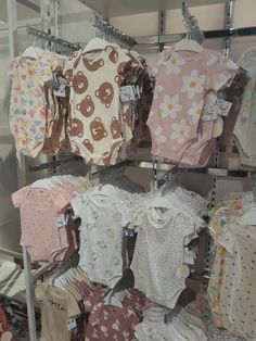 several baby ones are hanging on the rack in front of other ones, all different colors and sizes