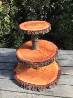 three tiered tree stump cake stand on a wooden deck with trees in the background