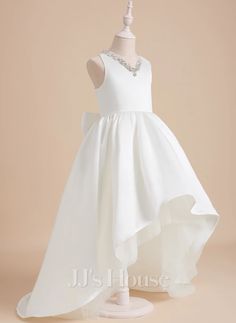 a white flower girl dress on a mannequin