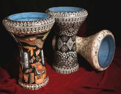 three vases sitting on top of a red cloth