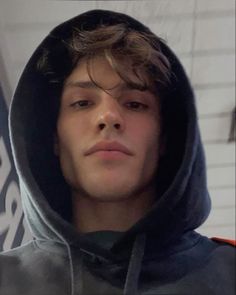 a young man wearing a hoodie looking at the camera