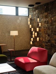 a living room filled with furniture next to a wall covered in stone walls and flooring