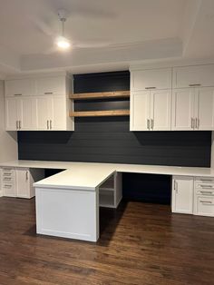 an empty office space with white cabinets and black accent wall paneling on the walls