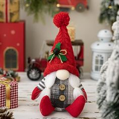 a red and white christmas gnome sitting next to presents