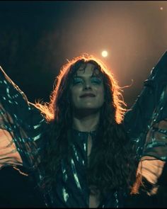 a woman with long hair standing in the dark