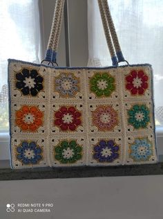 a crocheted bag hanging from a window sill