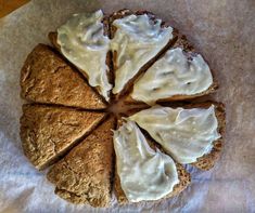 a piece of bread with white frosting on it sitting on top of wax paper