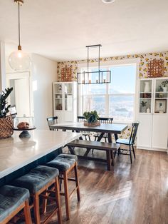 a dining room table and chairs in front of a window