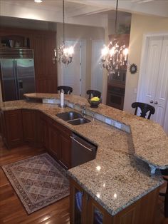 a large kitchen with granite counter tops and an island in front of the stove top