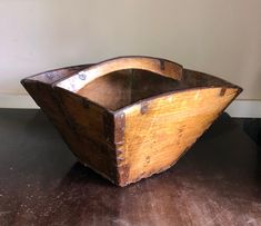 an old wooden boat sitting on top of a table next to a wall and floor