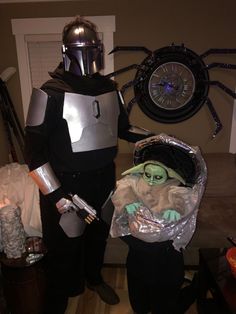 two people dressed up as star wars characters and one is holding a baby yoda