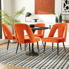 an orange dining room set with four chairs and a black table in front of a window