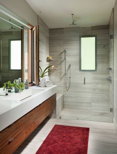 a bathroom with a red rug on the floor