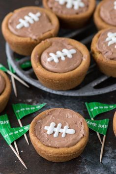 chocolate cupcakes decorated with football decorations on top of each other and toothpicks in the middle