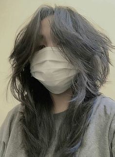 a woman wearing a face mask with long hair