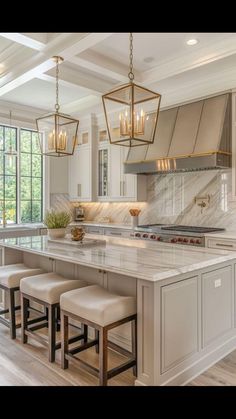 a large kitchen with an island and stools next to it, along with two windows