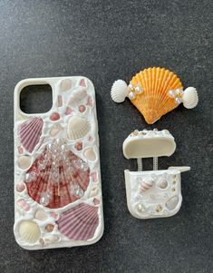 there are shells and seashells on the table next to an iphone 5g case