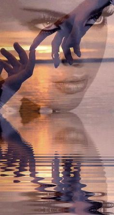 a woman's face is reflected in the water as she holds her hand out