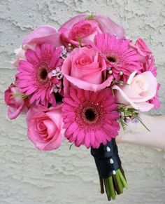 a person holding a bouquet of pink flowers